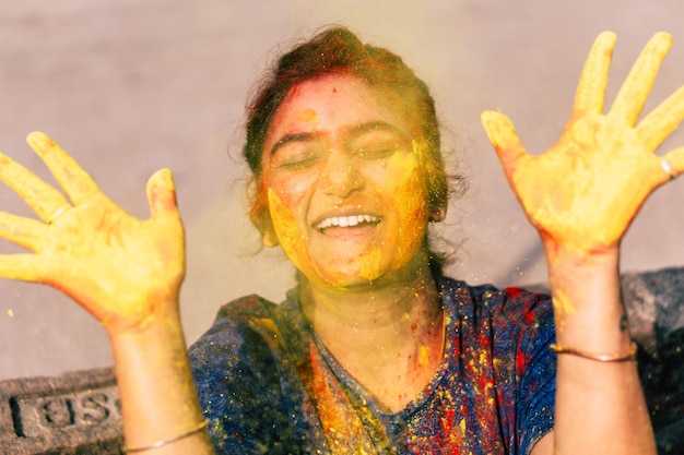Foto close-up di una donna sorridente coperta di vernice a polvere