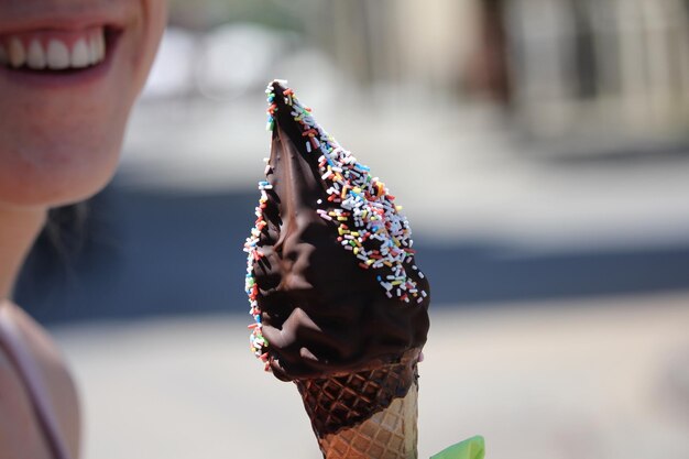 Foto close-up di una donna sorridente con un gelato in mano