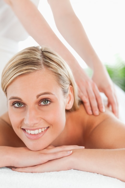 Close up of a smiling woman relaxing on a lounger during a massage