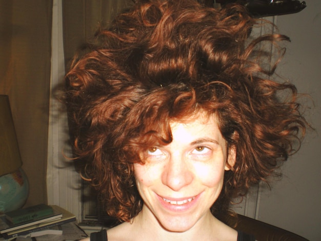 Photo close-up of smiling woman with messy short hair at home