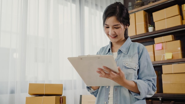 close-up of smiling young woman holding checklist in home office