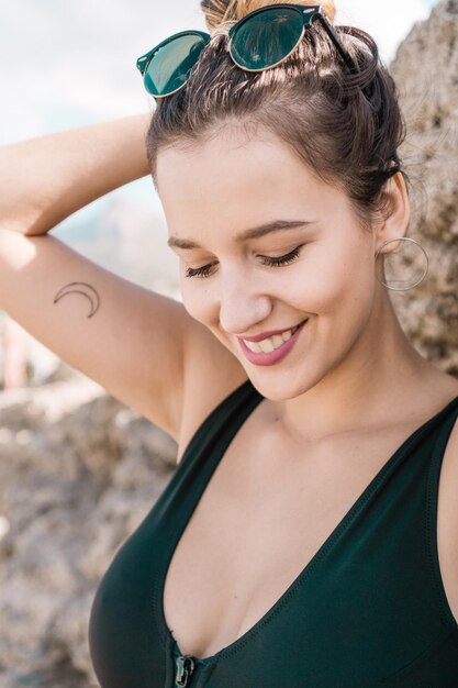 Photo close-up of smiling young woman standing against rock formation