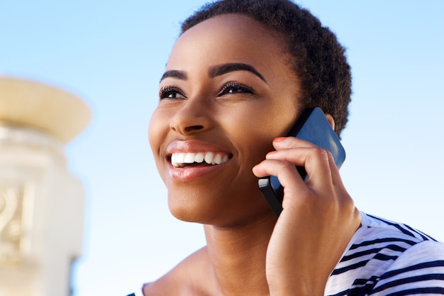 Close up smiling young woman talking on mobile phone 