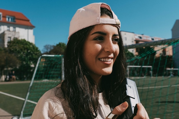 Photo close-up of smiling young woman with camera