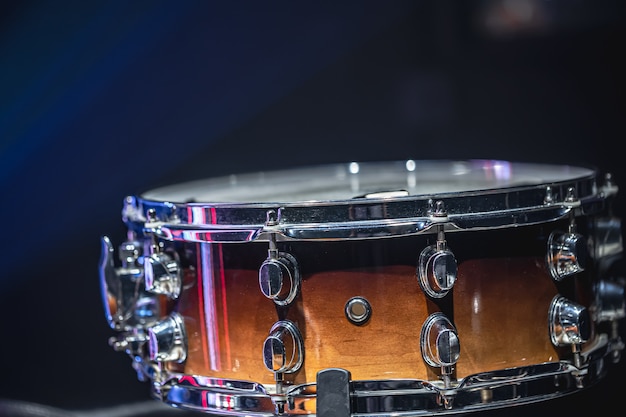 Close-up of a snare drum, percussion instrument on a dark background with haze, beautiful lighting.