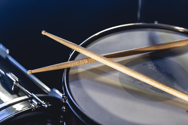 Close-up snaredrum en drumsticks op een donkere achtergrond