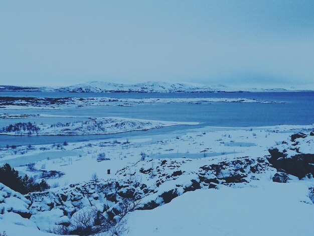 Close-up of snow covered landscape against blue sky