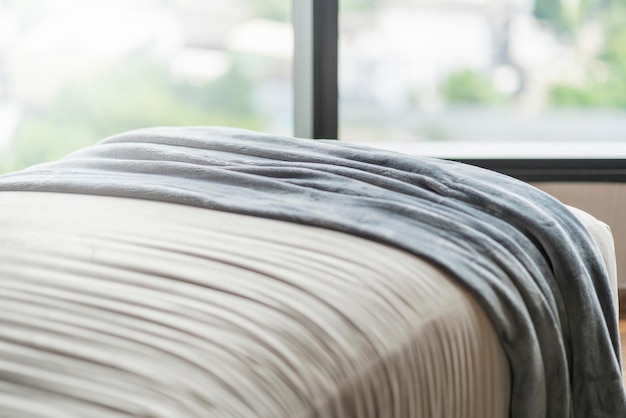 Close up soft bed blanket and fur carpet rug near window bedroom