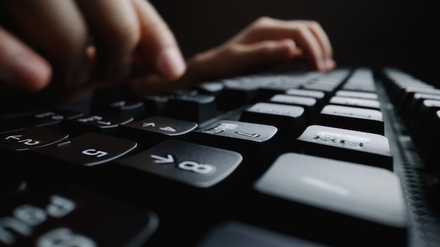 Close-up soft-focus finger typing on keyboard.