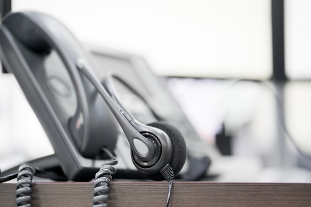 close up soft focus on headset with telephone devices at office desk 