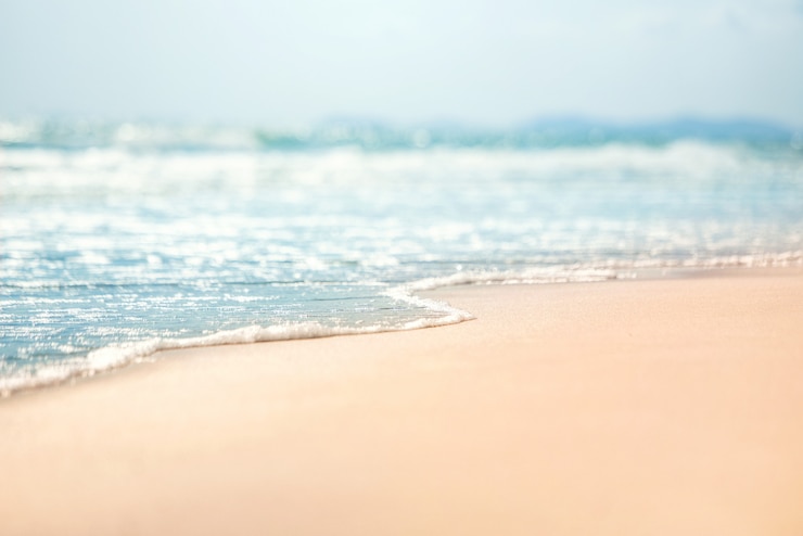 Close-up soft wave of the sea on the sandy beach.