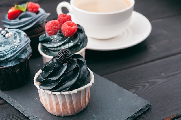 Close up of some decadent gourmet cupcakes frosted with a variety of frosting flavors