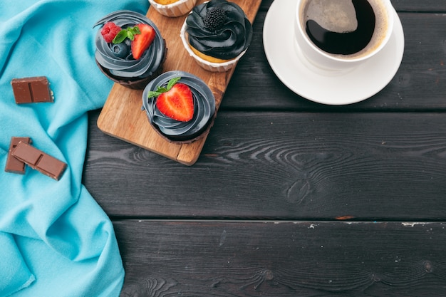 Close up of some decadent gourmet cupcakes frosted with a variety of frosting flavors