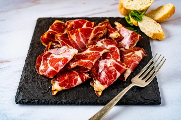 대리석 테이블에 있는 맛있는 돼지고기 본디올라 페타스의 클로즈업. 높은 전망.