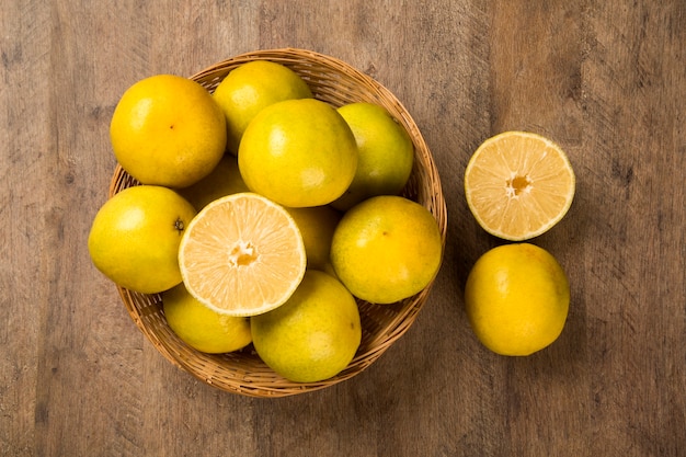 Close up of some oranges in a basket over a wooden surface. Fresh fruit.