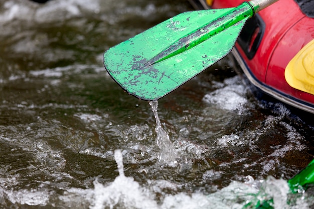 Photo close-up some part of paddle while young person rafting on the river