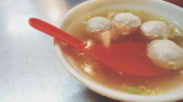 Close-up of soup with meatballs served on table