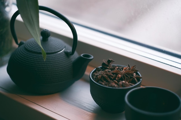 Photo close-up of spices in cup with teapot on table
