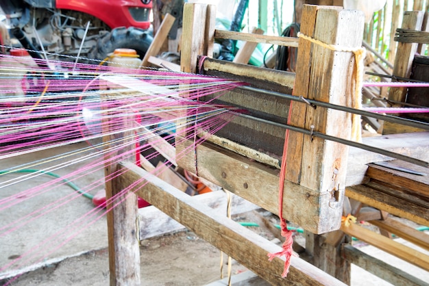 Close up Spinning production line. Spinning wood handmade with spindles  yarns