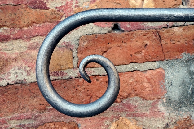 Close-up of spiral shape metal against brick wall