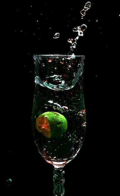 Close-up of splash drink in glass against black background