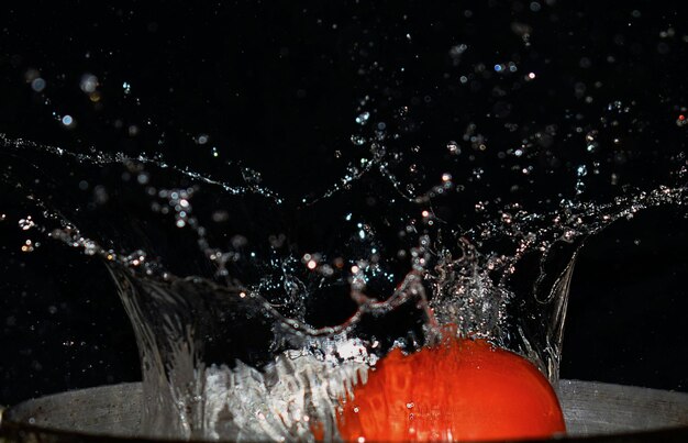 Photo close-up of splashing water against black background