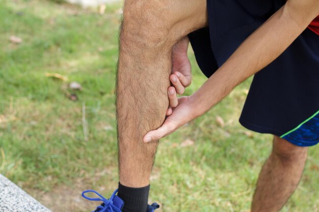 Photo close up of sport man suffering with pain on sports running knee injury after running