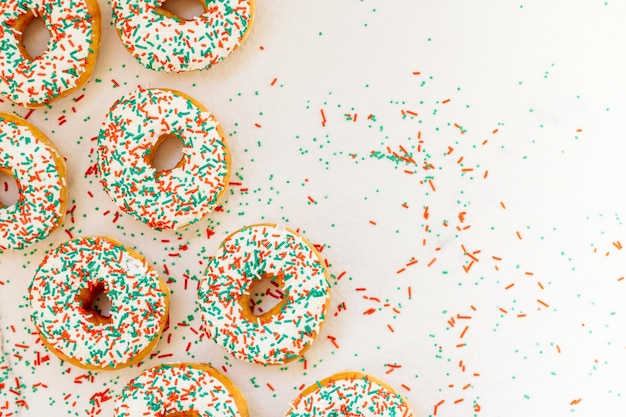 Close-up of sprinkles on donuts over white background