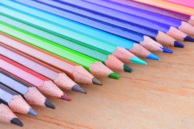 Close up stack colour pencils on wooden background