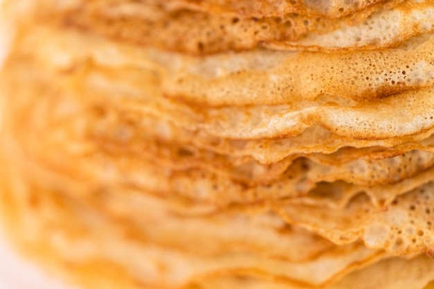 Close up. Stack of freshly baked crepes on a cake stand.