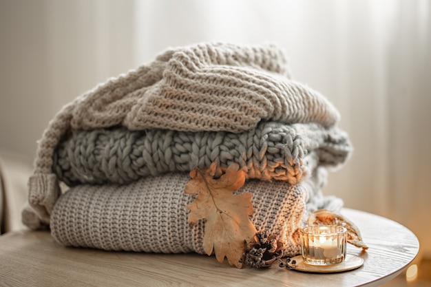 Close-up of a stack of knitted sweaters on a blurred background.