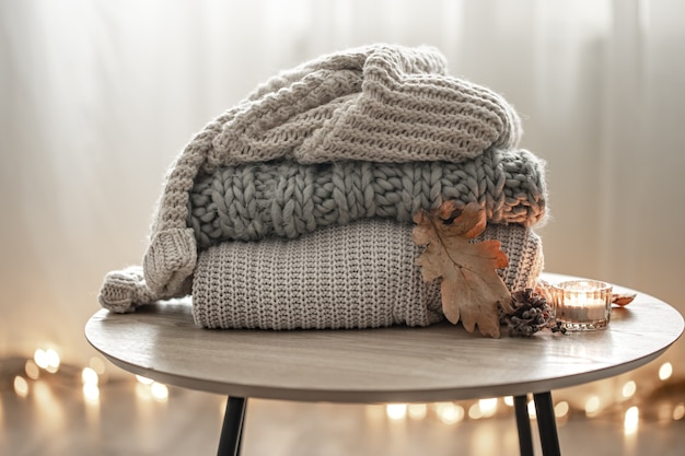 Close-up of a stack of knitted sweaters on a blurred background.