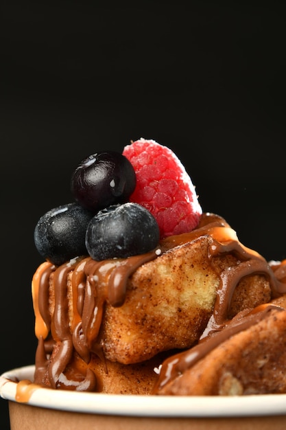 A close up of a stack of pancakes with chocolate sauce and berries