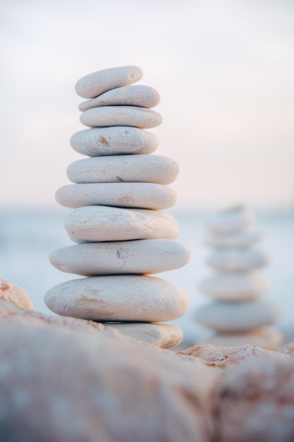 Photo close-up of stack of pebbles on rocks in sea