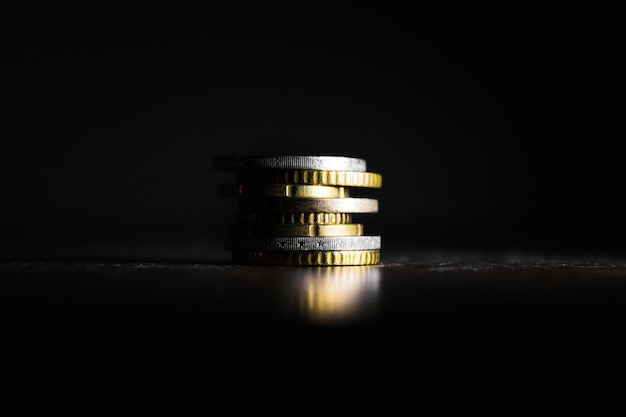 Close-up of stacked coins against black background