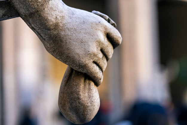 Close-up of statue hand with a bag of coins. Savings concept.