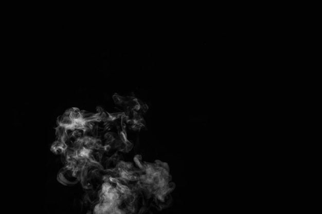 Close up of steam smoke on black background. White hot curly steam smoke isolated on black background, close-up. Create mystical Halloween photos. Abstract background, design element