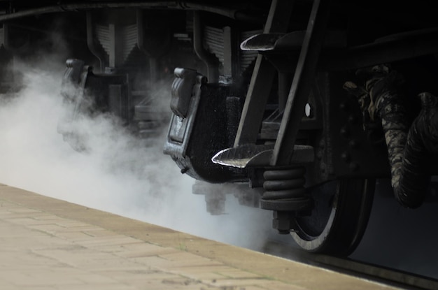 Foto prossimo piano di un treno a vapore sulla piattaforma della stazione ferroviaria