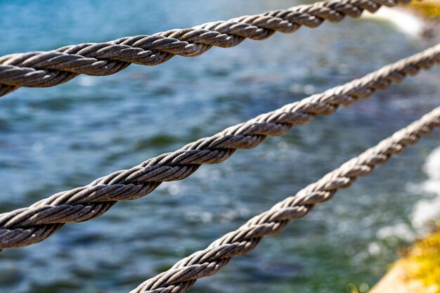 Foto corda d'acciaio vicino alla spiaggia e cordone grigio del mare