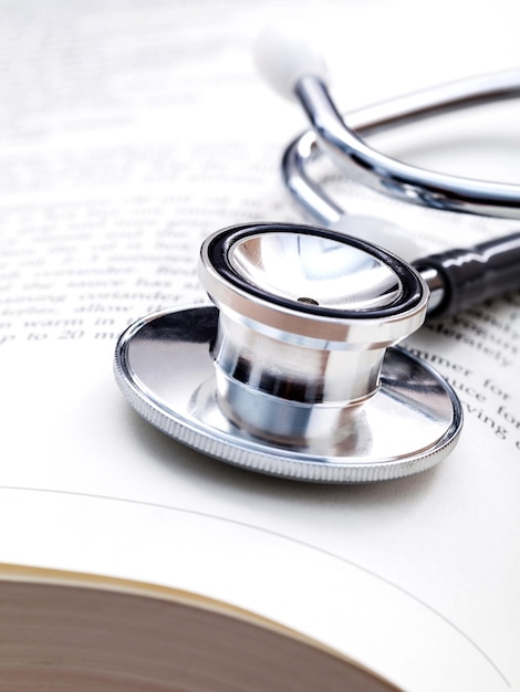 Photo close-up of stethoscope and book on table