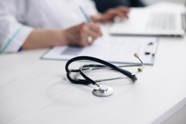 Close up of stethoscope medical equipment with female doctor working