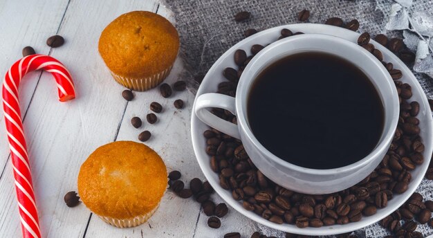 Close up still life cup of coffee with muffins freshly baked delicious muffins and cup of coffee on wooden table cup of fresh aromatic coffee and cupcake at table in cafe