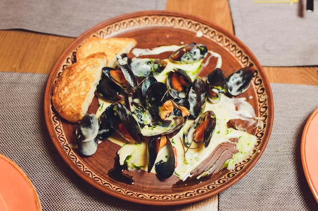Фото Острицы с сырным гратином, подаваемые на тарелке с зеленым гарниром.