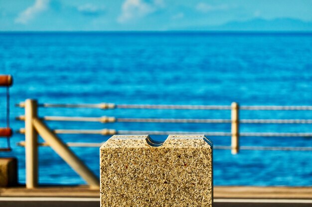 Close-up of stone structure by sea against blue sky and sea