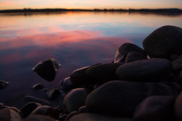 Foto prossimo piano delle pietre nel lago al tramonto