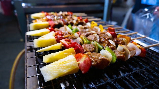 close-up straatverkoper grilt diverse BBQ-vlees en groente