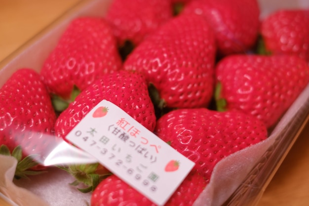 Photo close-up of strawberries in box on table