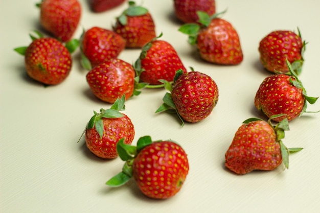 Close up of strawberries on a pastel yellow background