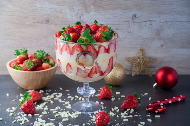 Photo close up strawberry dessert in glass with fresh strawberries and cream cheese on wooden