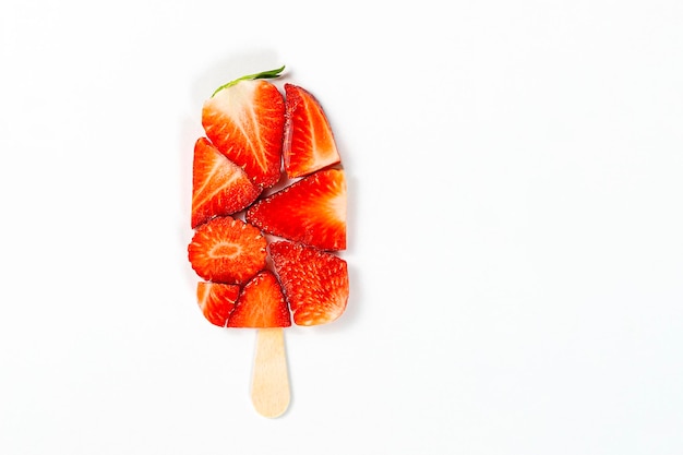 A close up of a strawberry ice cream on a stick